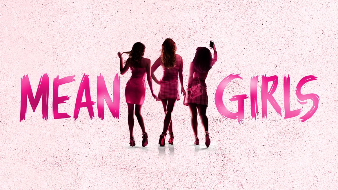 From behind, three young women wearing pink in front of a pink background and the words MEAN GIRLS