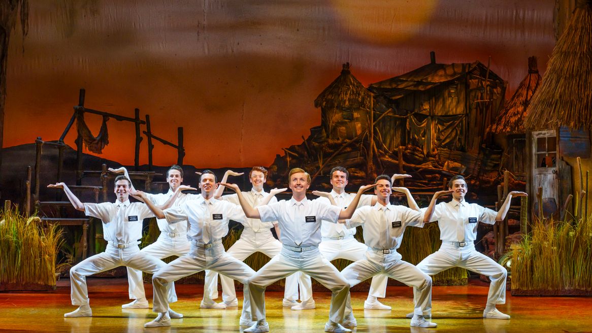 A group of young men in all-white Mormon missionary outfits pose in an unusual manner