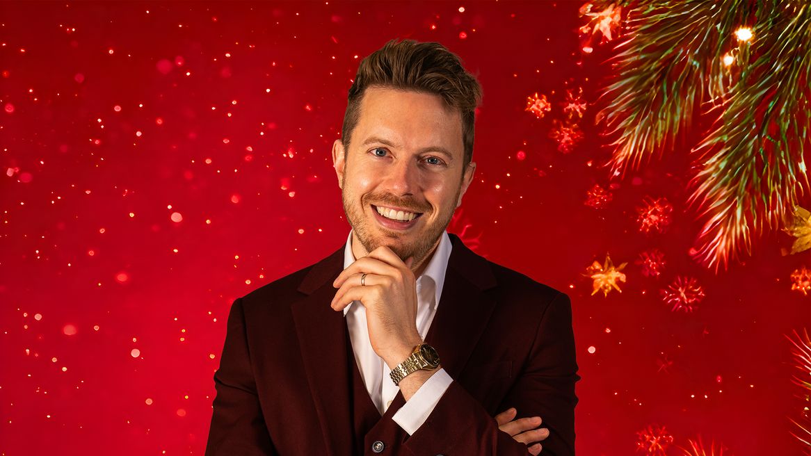 A man in a suit with his hand on his chin in front of a red festive background