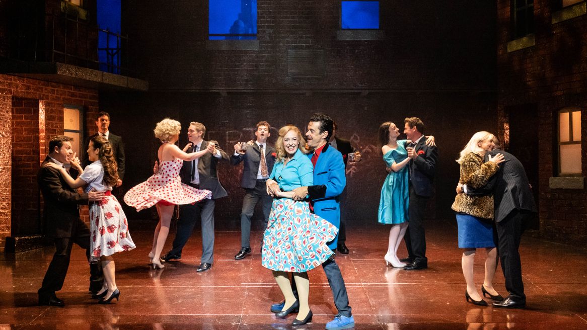 Couples in 50s inspired outfits dance in a street
