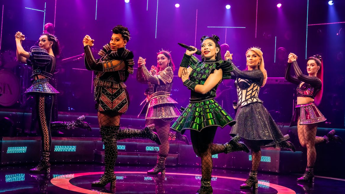 Six women in Tudor inspired popstar outfits dance together