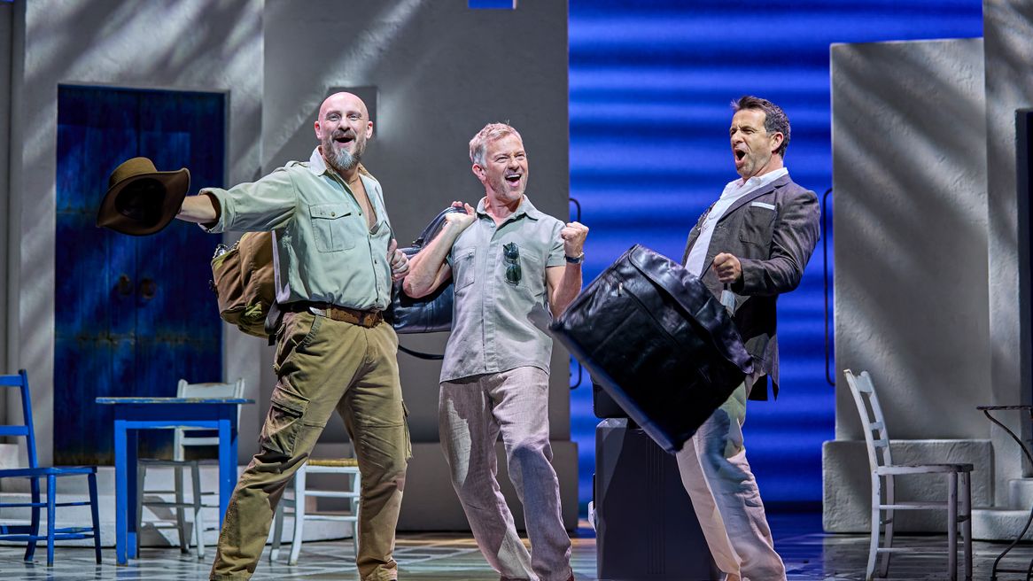 Three men cheer in a Greek hotel