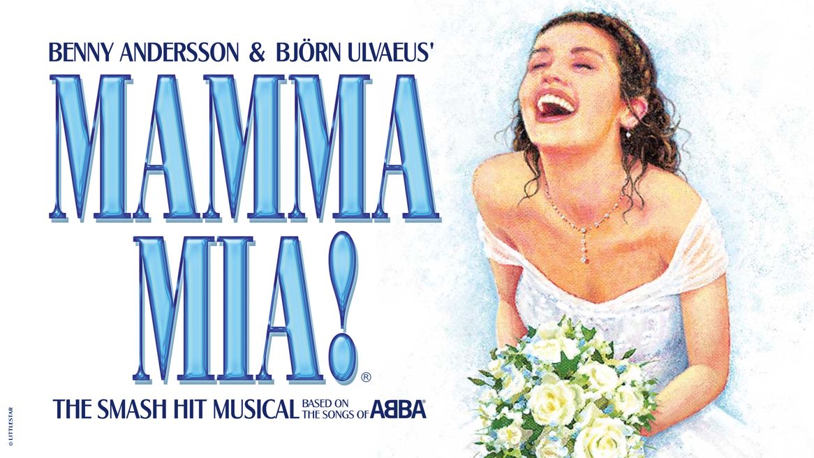 A woman in a bridal gown and veil holding a bouquet laughs