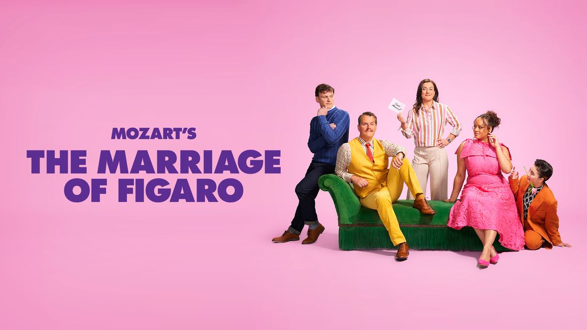 Five people in brightly coloured clothing pose in front of a pink background
