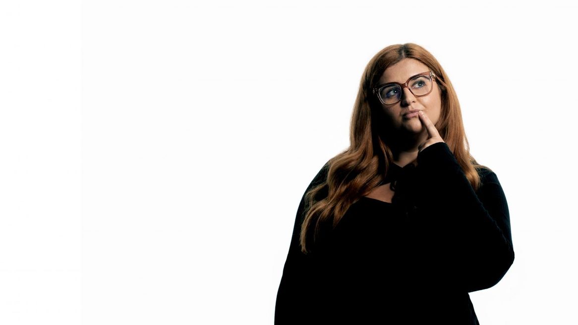 Comedian looking thoughtful with her finger close to her mouth