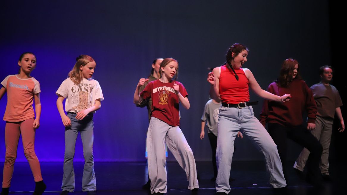 Stage shot of girls dancing in a line.