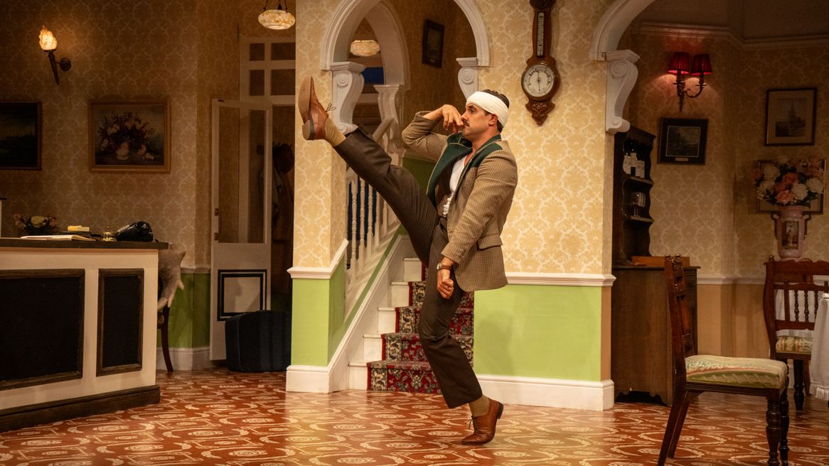 A man with a bandaged head pretends to walk like Hitler