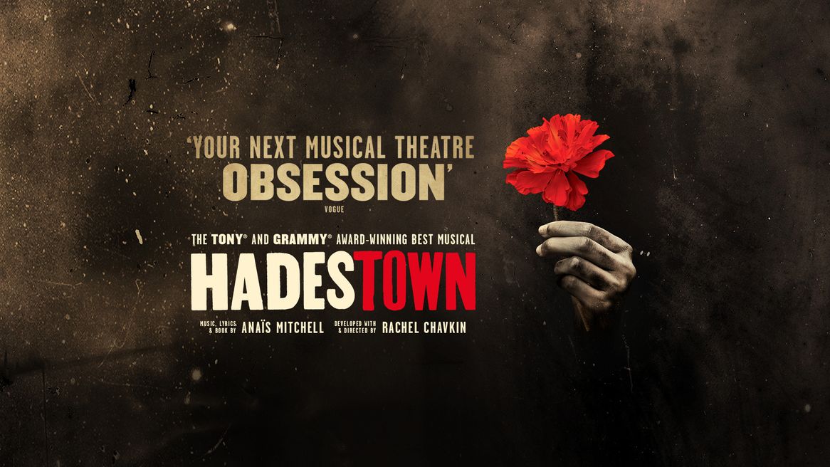 A hand holds a single red flower on front of a dark grungy background