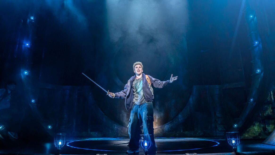 Teenage boy holds a sword with his arms outstretched