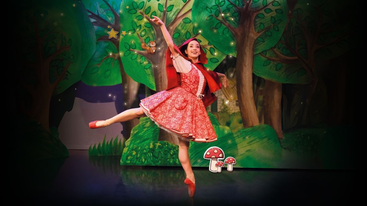 A female ballet dancer dances dressed as Little Red Riding Hood
