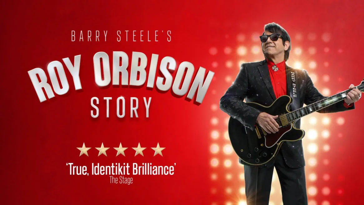 Barry Steele dressed as Roy Orbison poses with a guitar