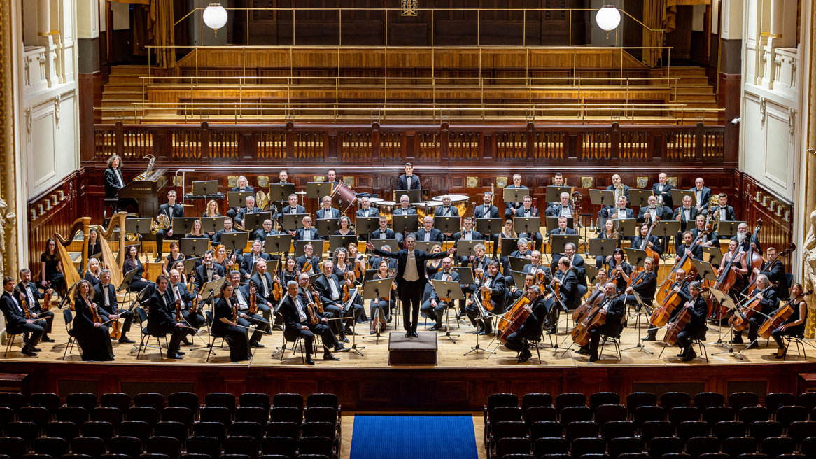An orchestra on a stage faces the audience