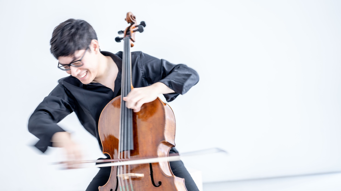 A young man in a black shirt plays the cello