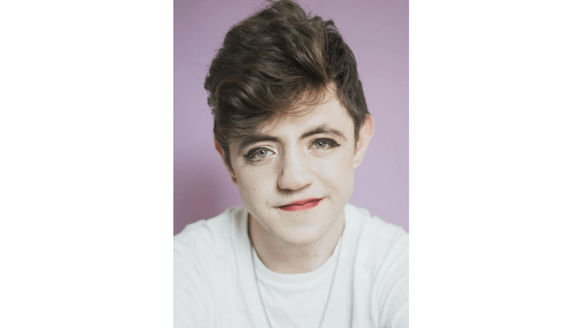 Headshot of comedian Sam Serano wearing a white t-shirt and bright red lipstick