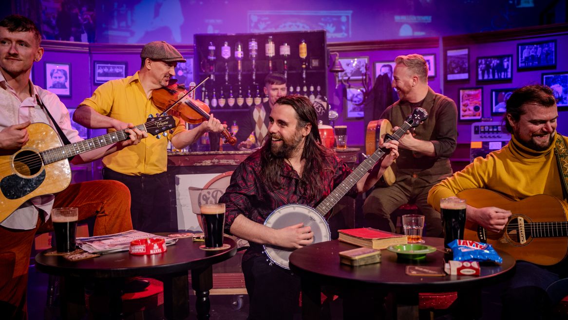 A group of men play guitars in a pub